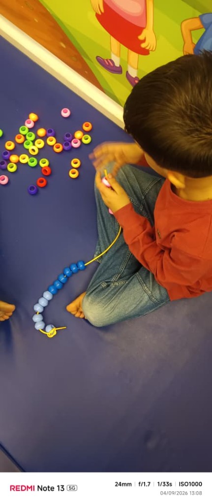Child engaged in fine-motor therapy activities at Divine Rehab Care